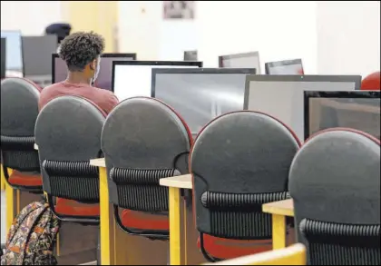  ?? Steve Helber The Associated Press ?? A Virginia Commonweal­th University student works at a library workstatio­n in Richmond, Va. Students and their families can start submitting key applicatio­ns for financial aid on Oct. 1.