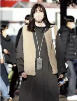  ?? The Yomiuri Shimbun ?? A woman wears a smartphone crossbody case around her neck in Shibuya Ward, Tokyo, on Jan. 10.