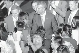  ?? CHARLES DHARAPAK/ASSOCIATED PRESS ?? A woman takes a “selfie” of herself as President Barack Obama greets audience members at a town hall-style event with 400 young leaders from throughout Southeast Asia at the University of Malaya in Kuala Lumpur, Malaysia, on Sunday.