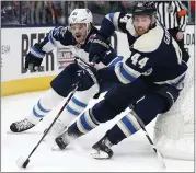  ?? JAY LAPRETE — THE ASSOCIATED PRESS ?? Columbus’ Vladislav Gavrikov, right, tries to clear the puck as Winnipeg’s Mason Appleton defends in the third period.