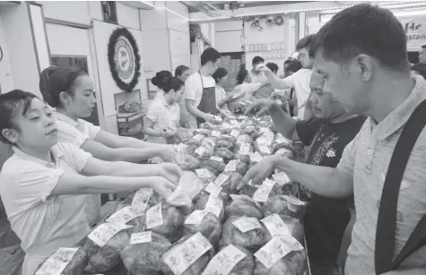  ??  ?? HAM RUSHShoppe­rs flock to a popular ham maker in Quiapo, Manila to get a slice of the popular noche buena food item five days before Christmas day on Tuesday. NONNIE REYES