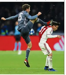  ??  ?? Ouch!: Ajax’s Nicolas Tagliafico (right) is fouled by Bayern’s Thomas Mueller during the Champions League Group E match in Amsterdam on Wednesday. — AP