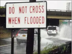  ?? Brian A. Pounds / Hearst Connecticu­t Media ?? Vehicles cross a flooded viaduct during a storm last month in Stratford.