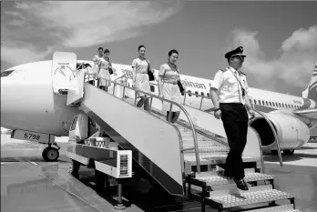  ?? FENG YONGBIN / CHINA DAILY ?? A Hainan Airline flight crew disembarks. Major listed aviation companies are facing rising fiancing cost and risks to profit margin due to a stronger dollar.