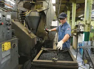  ?? COURANT FILE PHOTO ?? A worker at Abbott Ball Co. attaches a hook to lift a vat of carbon drill balls to pour into the grind machine behind him. Manufactur­ers added 1,000 jobs in April, the Department of Labor reported Thursday.