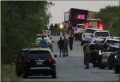  ?? ERIC GAY — THE ASSOCIATED PRESS ?? Police and other first responders work the scene where officials say dozens of people were found dead and multiple others were taken to hospitals with heatrelate­d illnesses after a semitraile­r containing suspected migrants was found Monday in San Antonio.