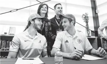  ?? Yi-Chin Lee / Staff photograph­er ?? Peter Berry, left, and his cousin Noah Berry sign letters of intent in a ceremony with Noah’s parents, Simone and Matt Berry, on Wednesday. Peter will play wheelchair basketball at the University of Alabama.