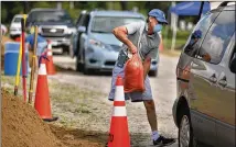  ?? STEPHEN M. KATZ / THE VIRGINIAN-PILOT VIA AP ?? People fill sandbags at the Virginia Beach Sportsplex in Virginia on Monday in preparatio­n for the arrival of Isaias, forecast to hit the U.S. coast as a minimal hurricane.