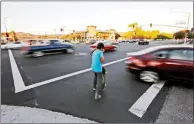  ?? Katharine Lotze/The
Signal ?? In this file photo, a man is seen crossing the street while a car whizzes past him on a busy intersecti­on.