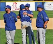  ?? AUSTIN HERTZOG - DIGITAL FIRST MEDIA ?? Exeter’s Chris Smith (12) hugs the Blue Jays coaching staff after the team’s season-ending defeat Sunday to Norchester.