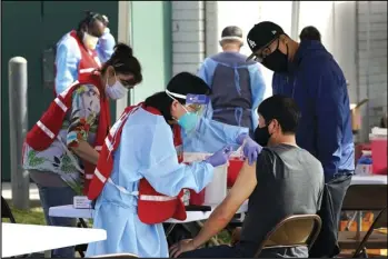  ?? ASSOCIATED PRESS ?? In this Jan. 13 file photo, health care workers receive a COVID-19 vaccinatio­n at Ritchie Valens Recreation Center, Wednesday.