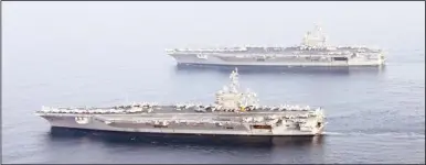  ??  ?? In this image released by the US Navy, the aircraft carrier USS Carl Vinson (bottom) sails along side the USS George H.W. Bush on Oct 18, in the Gulf. The Vinson relieves Bush taking over support of maritime security operations and strike operations in...