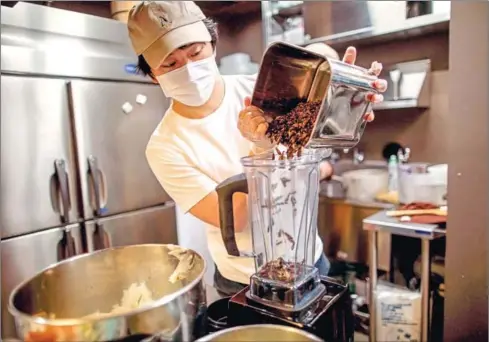  ?? AFP ?? Kento Sekine blends dried crickets, used as an ingredient as part of cricket ramen home-cooking kits, at a kitchen in Tokyo.