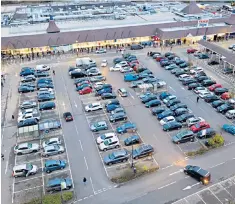  ??  ?? Customers queue to enter a Tesco store in Liverpool, right, while shoppers in New Maldon, south-west London, left, fill up the car park at a Tesco Express store ready for the doors to open at 6am