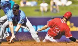  ?? Matt York Associated Press ?? THE ANGELS’ Andrelton Simmons steals second base as the Seattle Mariners’ Patrick Wisdom fields the late throw during an exhibition game.