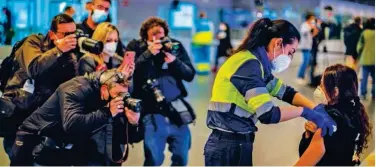  ?? Associated Press ?? ↑
A police officer receives a COVID-19 vaccine at the Wanda Metropolit­ano stadium in Madrid, Spain, on Thursday.