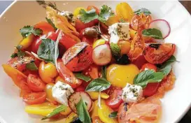  ??  ?? A tomato salad with feta, garlic and Moroccan olives is a Mediterran­ean delights that could serve as a meal all on its own.