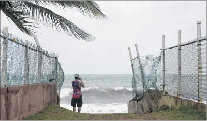  ?? AP PHOTO ?? A man photograph­s the ocean before the arrival of Hurricane Irma, in luquillo, Puerto Rico, Wednesday. Irma roared into the Caribbean with record force early Wednesday.