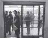  ?? RICHARD PIPES/JOURNAL ?? Albuquerqu­e police officers wait while handcuffed suspects arrested in Operation Fiesta One wait to be fingerprin­ted and photograph­ed at the jail booking desk in October 1977.