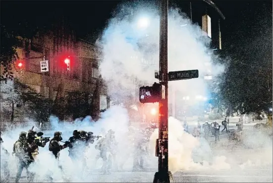  ?? NOAH BERGER / AP ?? Agentes federales de Portland usan munición de control de multitudes para dispersar a los manifestan­tes contra la discrimina­ción racial