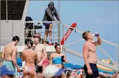  ?? Amy Beth Bennett / Associated Press ?? A Fort Lauderdale Ocean Rescue lifeguard watches over beachgoers during Spring Break on Fort Lauderdale Beach, Fla., Tuesday.