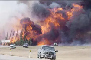  ?? cp Photo ?? A giant fireball is seen as a wild fire rips through the forest 16 km south of Fort Mcmurray, Alta., on highway 63 on May 7, 2016. Federal officials raised the possibilit­y of relaxing competitio­n and fuel quality rules to ensure a stable supply of fuel...