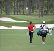  ?? AP-Phelan M. Ebenhack ?? Rory McIlroy, of Northern Ireland, walks to his ball on the seventh fairway while wearing colors honoring Tiger Woods during the final round of the Workday Championsh­ip golf tournament Sunday in Bradenton, Fla.