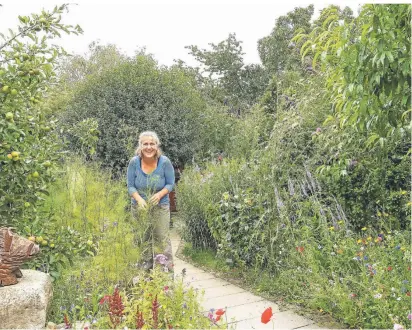  ?? FOTO: R. KLAPPROTH ?? Sandra Klein ist immer wieder überrascht, was alles in ihrem Naturgarte­n wächst und blüht. Kräuter wie das Fenchelgrü­n in ihrer Hand, Gemüse und Wildpflanz­en bieten Lebensraum für Vögel, Kleintiere und Insekten.