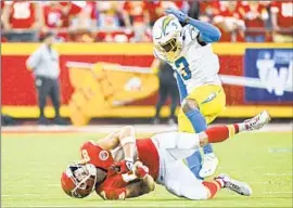  ?? Peter Aiken Associated Press ?? DERWIN JAMES JR. of the Chargers tackles Chiefs tight end Travis Kelce during the teams’ AFC West matchup in September. They’ll battle again Sunday.