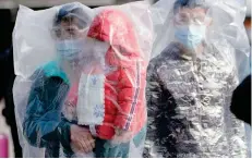  ??  ?? مسافرون يرتدون أقنعة واقية ويتدثرون بأكياس البلاستيك يخرجون من محطة قطار شنغهاي في الصين. À رويترز