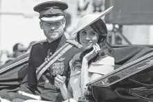  ?? Niklas Hallen / AFP / Getty Images ?? Britain’s Prince Harry, Duke of Sussex, and Meghan, Duchess of Sussex, return in a horse-drawn carriage after attending the Trooping the Color ceremony.