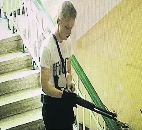  ?? CCTV FOOTAGE ?? A CCTV image appears to show student Vladislav Roslyakov stalking the halls of Kerch Polytechni­c College.