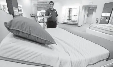  ??  ?? John Yelverton demonstrat­es the sleep technology that works in concert with the Sleep Number 360 Smart Bed.