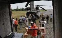  ?? Matias Delacroix / Associated Press ?? People unload humanitari­an aid from a U.S. Army helicopter at the airport in Les Cayes, Haiti, on Sunday.