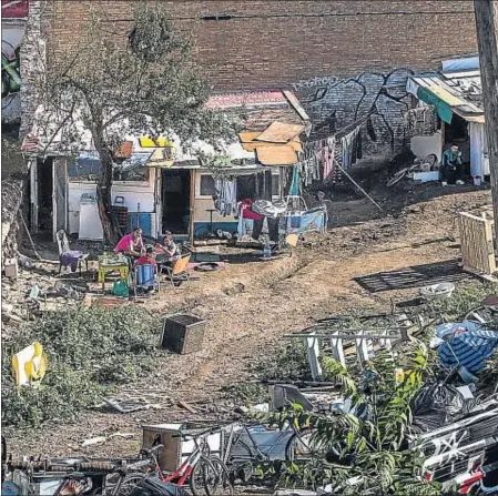  ??  ?? Una familia de origen rumano a la hora del almuerzo delante de su barraca, muy cerca del Auditori