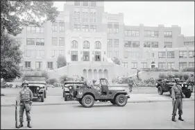  ?? AP FILE (1957) ?? Members of the 101st Airborne Division take up positions Sept. 26, 1957, outside Central High School in Little Rock, Ark. Then-president Dwight Eisenhower sent the 101st Airborne to Little Rock to protect Black students integratin­g Central High School.
