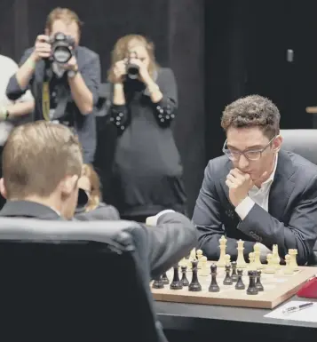  ??  ?? Magnus Carlsen, the reigning world chess champion, strokes his chin while deep in thought in his match against Fabiano Caruana at the world championsh­ips in London. Mr Carlsen, a Norwegian grandmaste­r, has held the title since 2013