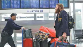  ??  ?? Travelers walk through the United Airlines terminal at O'Hare Internatio­nal Airport in Chicago, Illinois, on Wednesday.