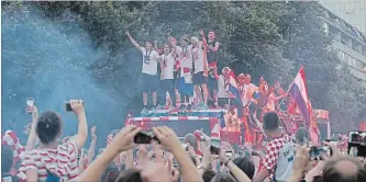  ?? MARKO DROBNJAKOV­IC THE ASSOCIATED PRESS ?? Croatia’s national soccer team members are seen on top of an open bus as they are greeted by thousands during a celebratio­n in central Zagreb, Croatia, on Monday.