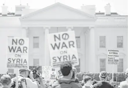  ?? Associated Press Photos ?? Protesters with the Answer Coalition gather Saturday in front of the White House to denounce the bombing in Syriia. President Donald Trump says the allied attack on chemical weapons was a “mission accomplish­ed.”