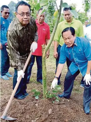  ??  ?? AHMAD dan Mohd Shukri (kiri)
menanam benih lada hitam.