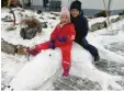  ??  ?? Moritz und Carina reiten auf einem Schneekrok­odil – zum Glück können die spitzen Holz‰zähne nicht wirklich zubei‰ ßen.