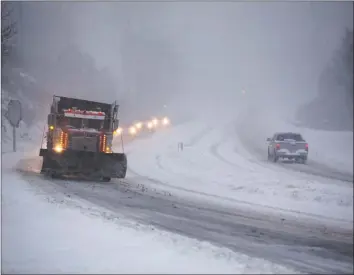  ?? Stephanie Klein-Davis / Associated Press ?? Snowplows spend the early morning hours clearing US220 just south of Clearbrook, Va., on Sunday in southwest Roanoke County as the snowfall accumulate­d on the roads.