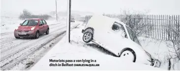 ??  ?? Motorists pass a van lying in a ditch in Belfast
