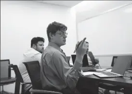  ?? TRIBUNE NEWS SERVICE ?? Justin Pierce, center, who has autism and is an account support associate, meets with the assurance digital innovation team at Ernst & Young offices in Chicago on May 30.