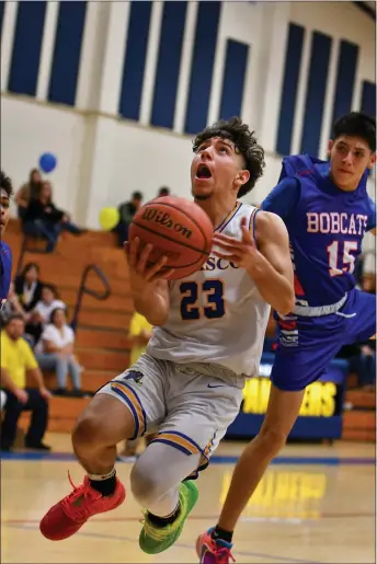  ?? JOHN T. DENNE/For the Taos News ?? Jeremiah Martinez goes up to the basket after zig-zagging through the McCurdy defense in the second half of their game Saturday night in Peñasco.