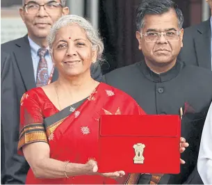  ?? REUTERS ?? India’s Finance Minister Nirmala Sitharaman shows the folder containing the federal budget outside parliament in New Delhi yesterday.