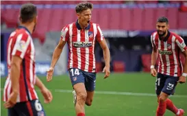  ??  ?? Atletico Madrid's Marcos Llorente (C) celebrates with teammates after scoring a goal against Eibar on Sunday