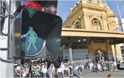  ??  ?? MELBOURNE: New traffic signals designed to equal the gender balance guide pedestrian­s across Swanston Street near Flinders Street railway station on Internatio­nal Women’s Day. — AFP MELBOURNE: