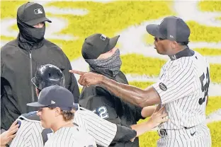  ?? KATHY WILLENS/AP PHOTOS ?? Third base umpire Jansen Visconti, center, restrains Yankees relief pitcher Aroldis Chapman, right, after the Rays and Yankees traded words after the Yankees’ 5-3 victory Sept. 1 at Yankee Stadium in New York. The altercatio­n ensued after Chapman threw a high pitch at Rays pinch hitter Michael Brosseau (top left) in the final at-bat of the game.